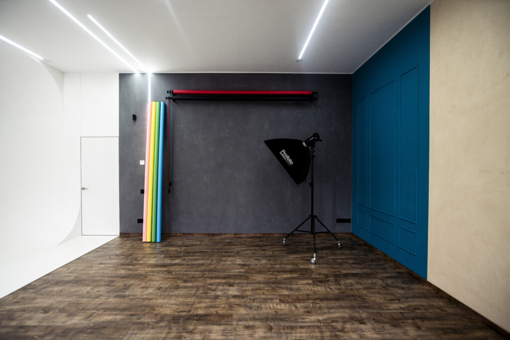 Fotostudio in Kyjiw: Shooting-Ecke mit strukturiertem Hintergrund, Papierrollen und Studiolicht.