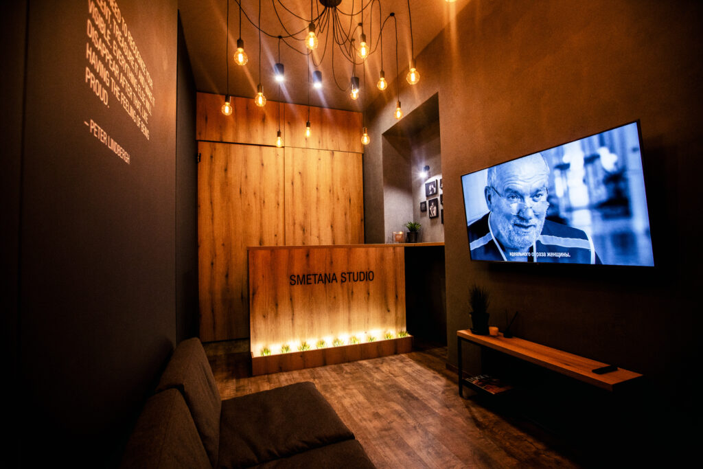 Empfangsbereich meines Fotostudios in Kyjiw mit Holztheke, warmem Licht und Smetana Studio Logo.