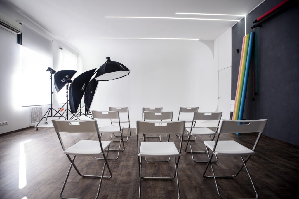 Fotostudio in Kyjiw: Shooting-Ecke mit strukturiertem Hintergrund, Papierrollen und Studiolicht.